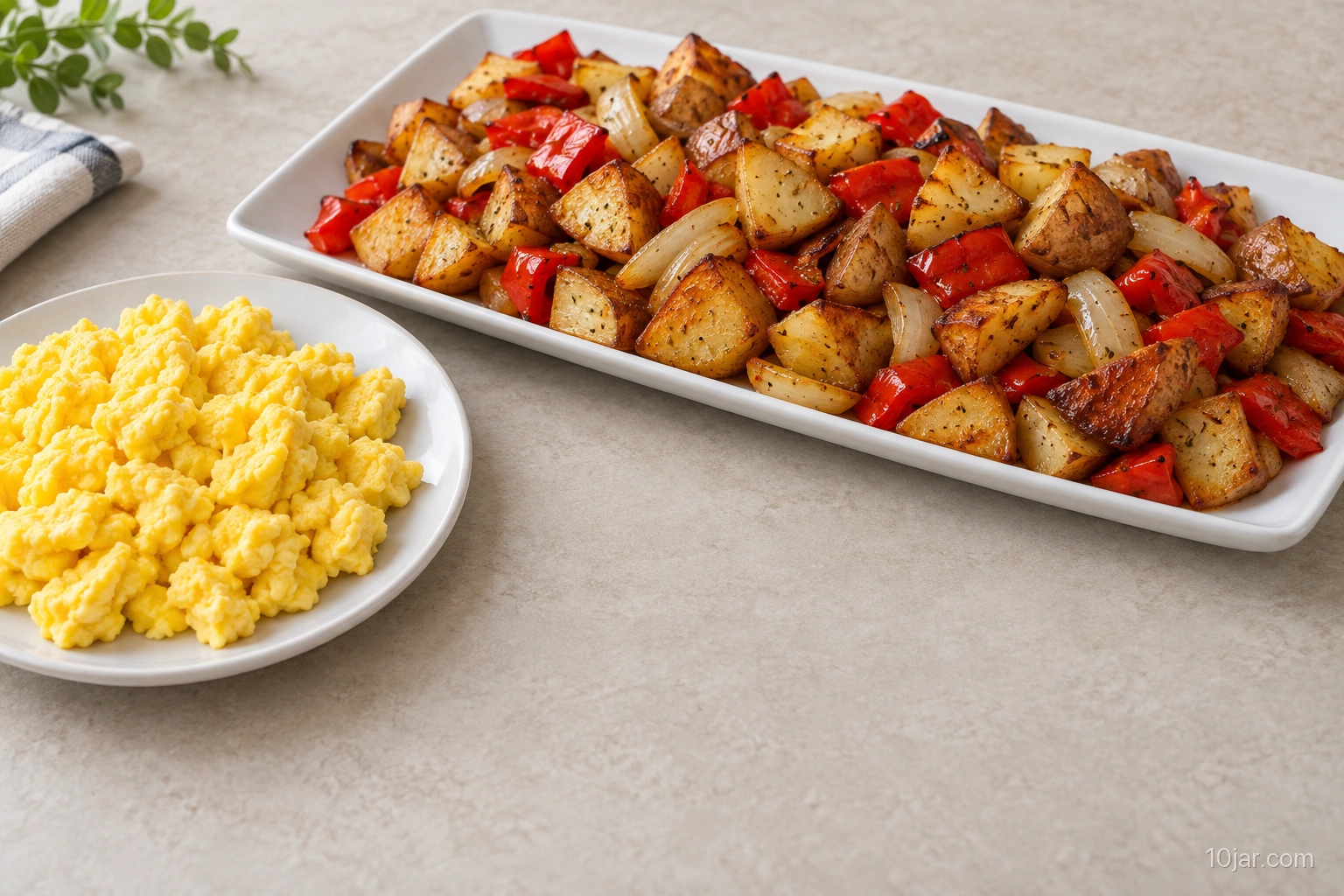 Roasted potato, red pepper, and onion breakfast hash on a wide platter with firm-cooked eggs served separately