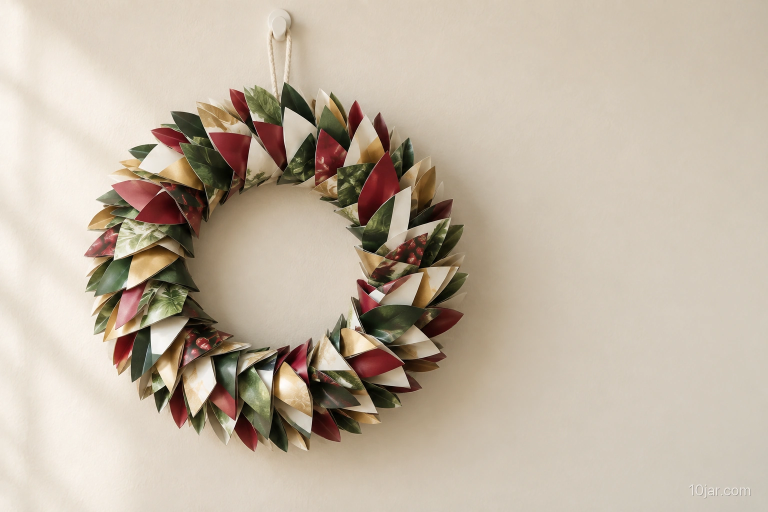 One twelve-inch folded magazine-paper Christmas wreath hanging from an existing indoor hook in a dry low-contact setting